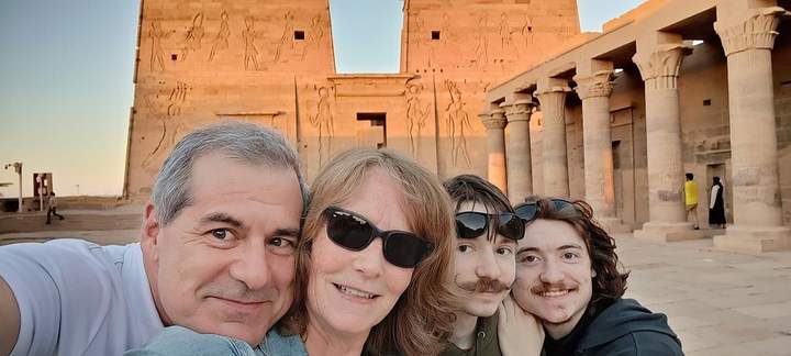 Familia tomándose una selfie frente al pilono iluminado por el sol del Templo de File, Asuán