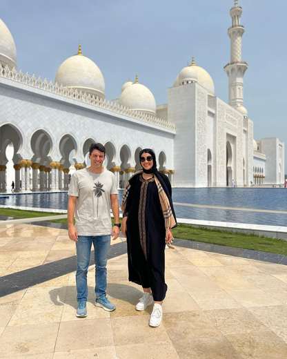 Pareja junto al estanque reflectante de la Gran Mezquita Sheikh Zayed, Abu Dabi